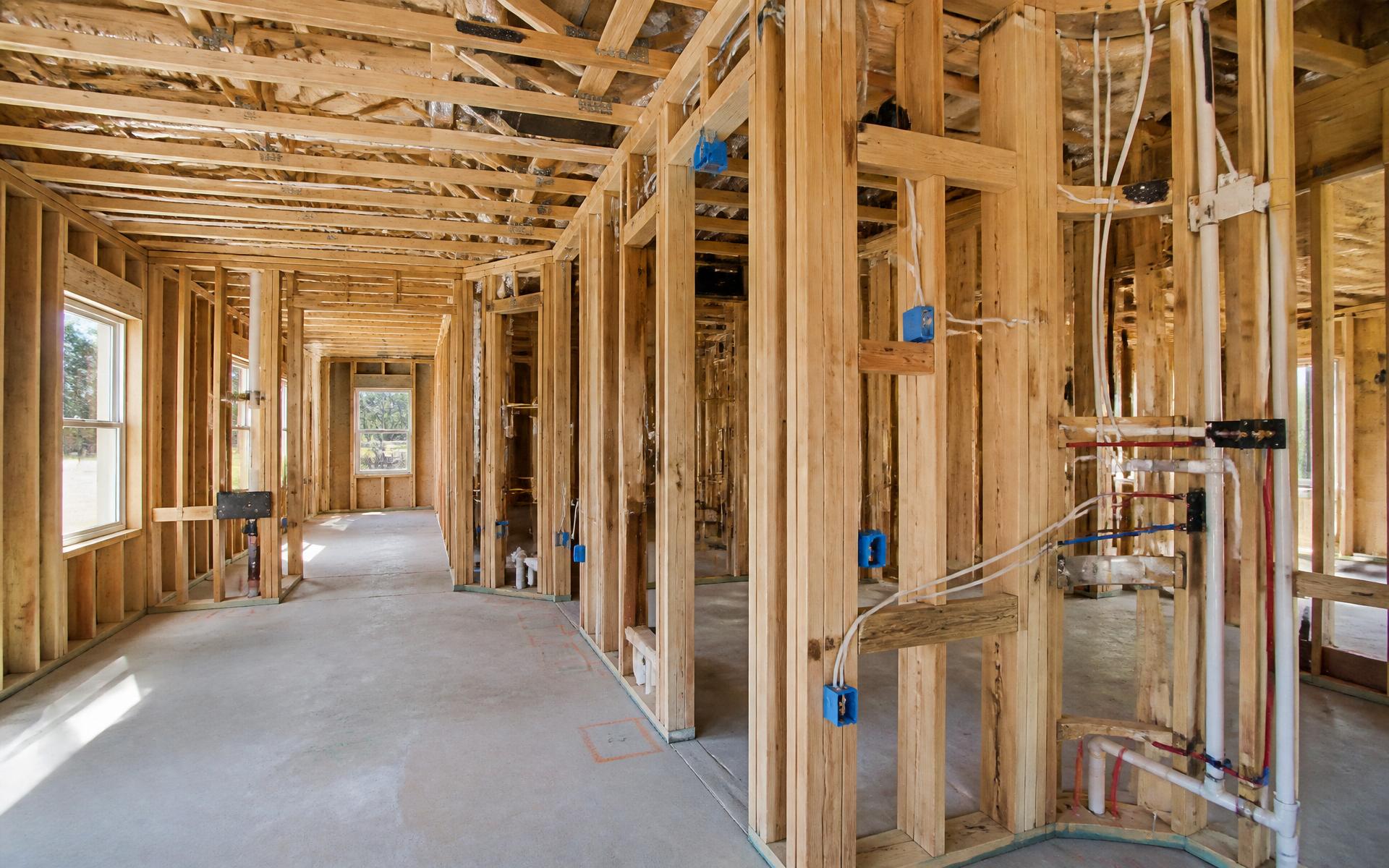 Interior of a pre-plaster residential construction site with exposed framing and services